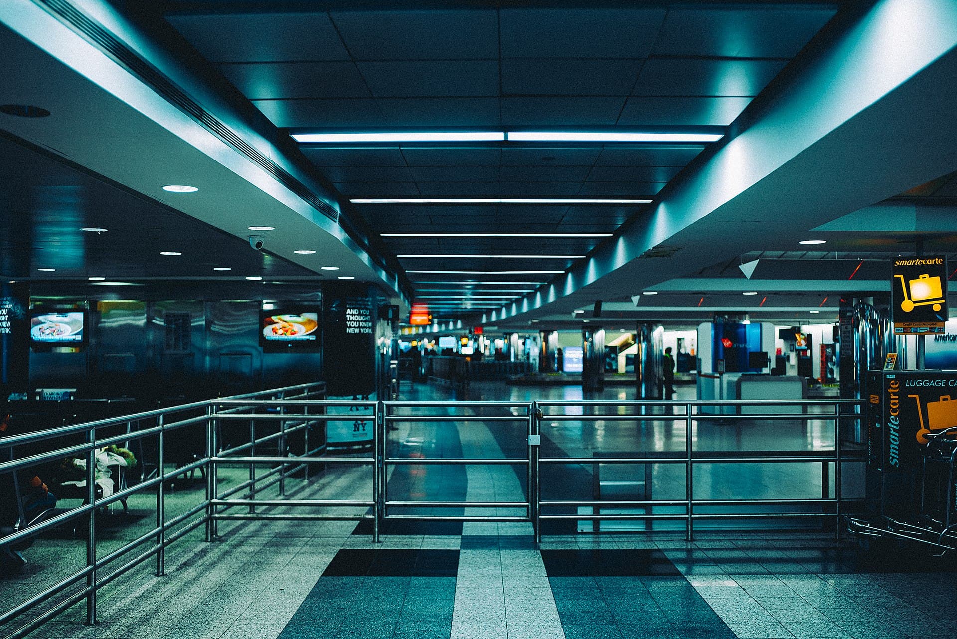 Baggage trolleys and an empty corridor in an airport arrivals hall