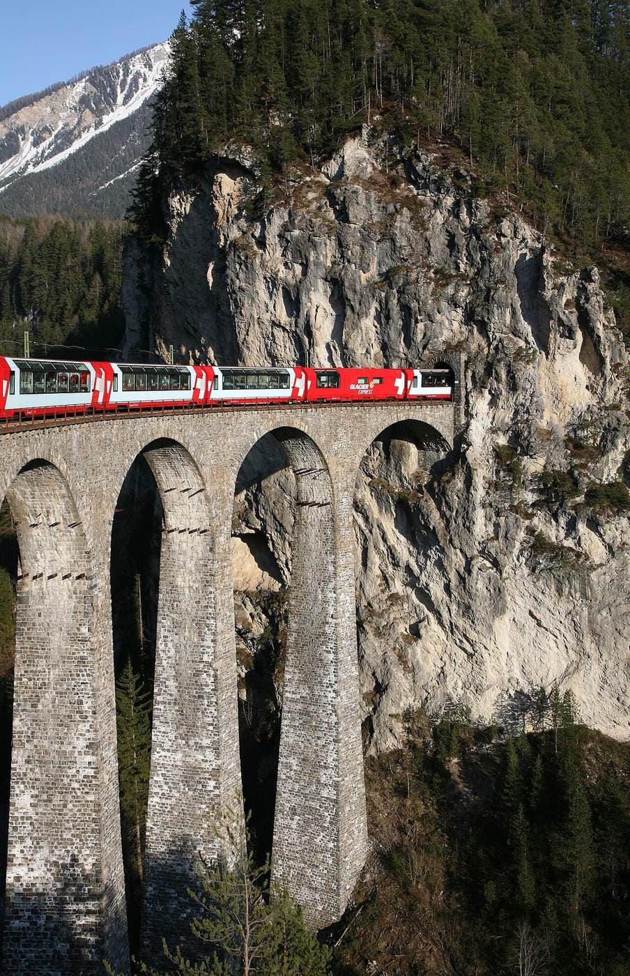 Passenger train moving through mountain landscape in Europe